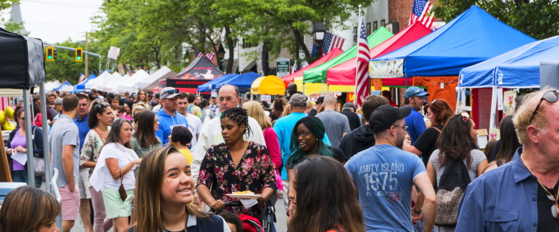 local street fair with vendors and happy attendees
